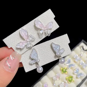 Elegant butterfly earrings with gradient crystal and white pearls on a display card