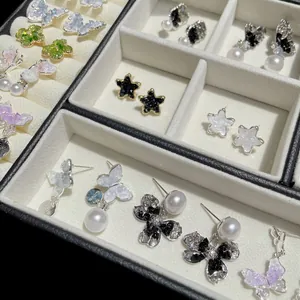 Elegant butterfly bow earrings with pearls and crystal rhinestones in a jewelry box