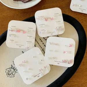 Ohrstecker-Set mit rosa Schmetterlingen und Zirkonia auf einer Wochentagskarte