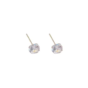 Orecchini a perno minimalisti in argento con zirconi a quattro griffe su sfondo bianco