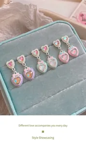 Dettaglio di tre paia di orecchini a cuore macaron con fiocchi in rosa, blu e viola