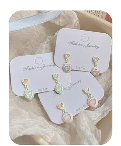 Dettaglio di orecchini a cuore macaron con fiocchi su cartoncini per perni in argento 925