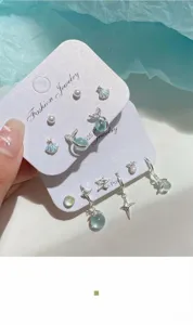 Set dettagliato di orecchini a tema marino con conchiglie, coda di sirena e perline