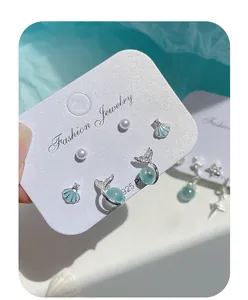 Dettaglio set orecchini in argento a tema marino con conchiglia e coda di sirena