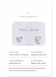 Detail of silver bow earrings with pearls featuring 925 silver posts and 1cm size