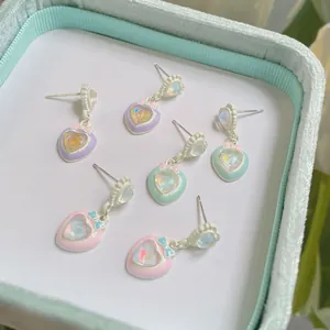 Orecchini a cuore pastello con fiocco in lavanda, menta e rosa su velluto