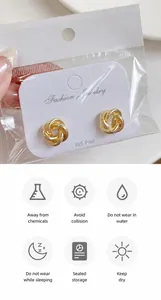Détail de boucles d'oreilles nœud doré avec tiges en argent S925 et guide d'entretien