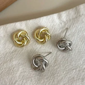Boucles d'oreilles nœud minimalistes en métal doré et argenté sur tissu texturé