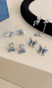 Detail of blue rhinestone bear and butterfly earrings with pearl accents on display