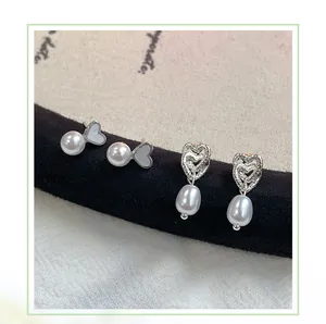 Dettaglio di orecchini di perle a forma di cuore su supporto di velluto nero elegante