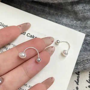 Minimalist U-shaped silver ear cuff with a polished metal bead and a white pearl