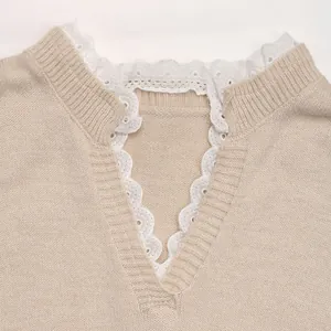 Close-up of beige knit sweater featuring a V-neckline with delicate white lace trim details
