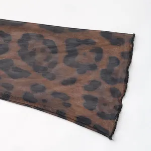 Detail of brown leopard print mesh fabric with lettuce hem on flared sleeves