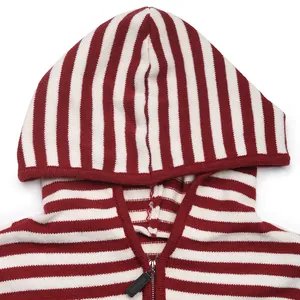 Detailed close-up of a red and white striped knit hoodie with a metal zipper and black puller