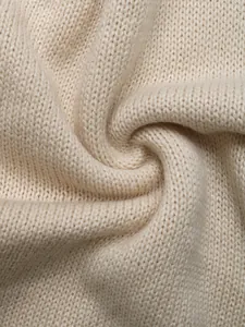 Close-up of premium cream knitted fabric texture with soft wool pattern detail