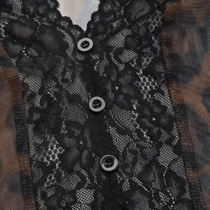 Detail of leopard mesh fabric with black lace trim and three front buttons on a bodysuit