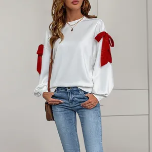Felpa da donna bianca con eleganti fiocchi rossi glitterati sulle spalle