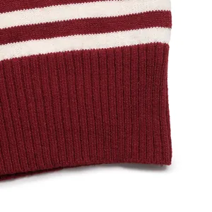 Close-up of burgundy knit sweater with white stripes and elastic ribbed cuffs detail