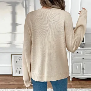 Beige loose-fit knit sweater for women with ribbed cuffs and hem seen from behind
