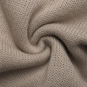 Macro detail of soft oatmeal knitted fabric texture with smooth stitch for women cardigan