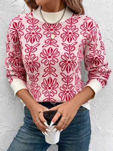 Dettaglio del maglione in maglia rosa con jacquard floreale rosso e polsini a costine bianche