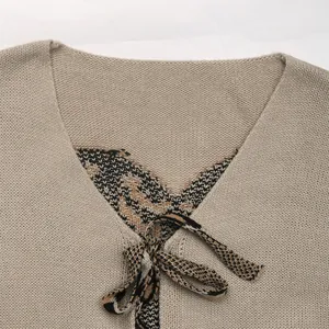 Close-up of V-neck cardigan featuring detailed knitted texture and patterned tie-up straps
