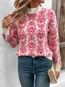 Dettaglio del maglione rosa a maglia con motivo floreale rosso e collo alto bianco a coste