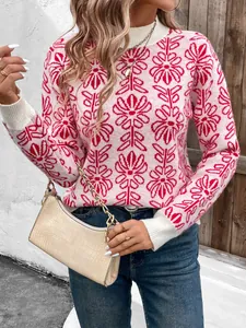 Dettaglio del maglione in maglia rosa con jacquard floreale rosso e polsini a coste