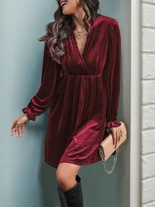 Détail de robe en velours bordeaux avec décolleté en V et poignets élastiques à volants