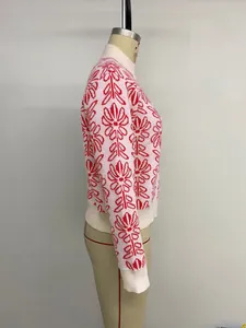 Dettaglio maglione rosa in maglia con jacquard floreale rosso e polsini bianchi