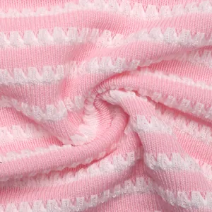 Detail von pink-weiß gestreiftem Strickstoff mit weicher Rippstruktur und Wellenmuster