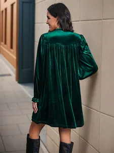 Vue arrière d'une robe en velours vert foncé à manches longues avec dos plissé et ourlet