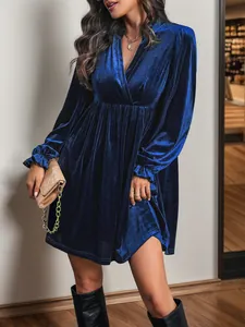 Détail de la texture velours bleu foncé avec décolleté en V et poignets volantés