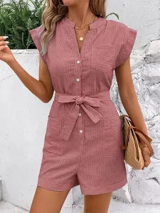 Detail of pink striped romper with V-neck, waist tie and button front in outdoor setting