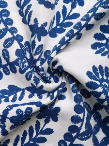 Detalle del patrón de hojas tropicales azules en tela blanca suave con caída elegante