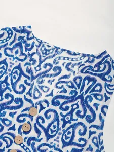 Detail view of V-neckline with wood buttons and blue abstract geometric print pattern