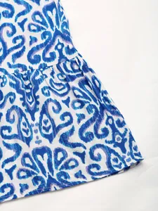 Detail of blue and white ikat print dress showing fabric texture and pleated hemline