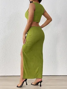 Detailed view of the textured sage green ruched fabric and high side slit on long skirt