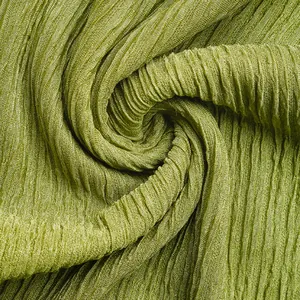 Detail of moss green ruched fabric with vertical pleats and silky shimmering texture