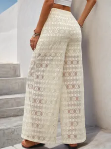 Détail du pantalon large en dentelle à taille haute avec des motifs ajourés au crochet raffinés