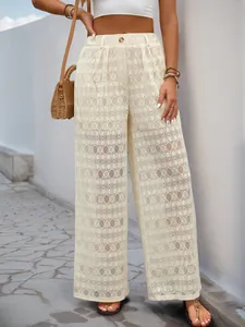 Détail du pantalon large en dentelle à taille haute avec motifs géométriques évidés