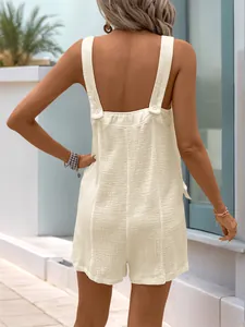 Rear view of off-white summer romper featuring textured fabric and wide straps with buttons