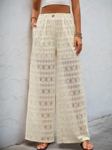 Détail du pantalon large en dentelle à taille haute avec broderie géométrique et poches latérales