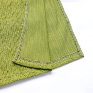 Macro detail of textured grass green fabric with pleated surface and fine rib knit lining