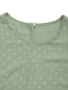 Detailed view of light green summer top featuring Swiss dot texture and round neckline