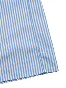 Gros plan sur l'ourlet précis et le tissu en coton à rayures bleues de la combinaison