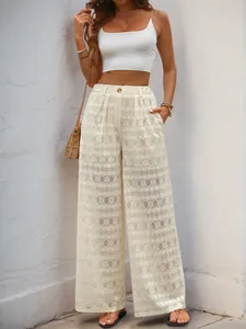 Détail du pantalon large en dentelle blanche à taille haute pour les vacances d'été