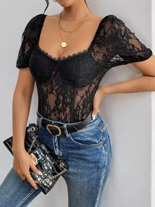 Detail of elegant black lace bodysuit with sheer floral patterns and gold chain bag