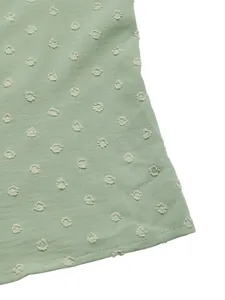 Detailed view of mint green blouse featuring 3D Swiss dots and neat hemline stitching