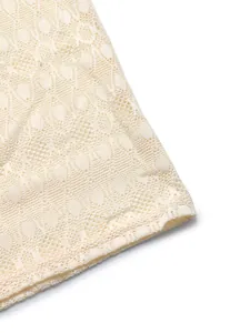 Gros plan sur le pantalon en dentelle beige avec motif floral et détails de l'ourlet
